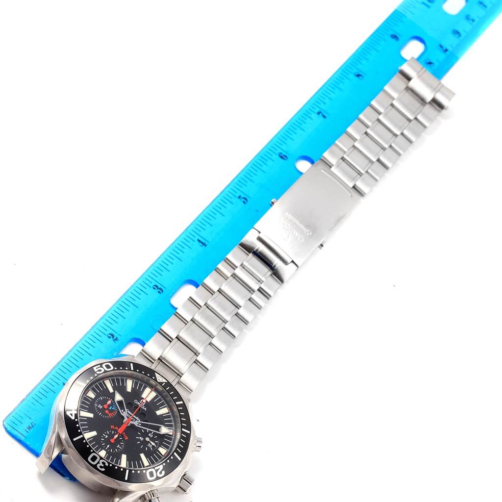 The Omega Seamaster 2569.50.00 Men
s Stainless Steel Black Dial 2569.50.00 Men
s Stainless Steel Black Dial watch is shown laid flat with its metal bracelet partially extended alongside a blue ruler.