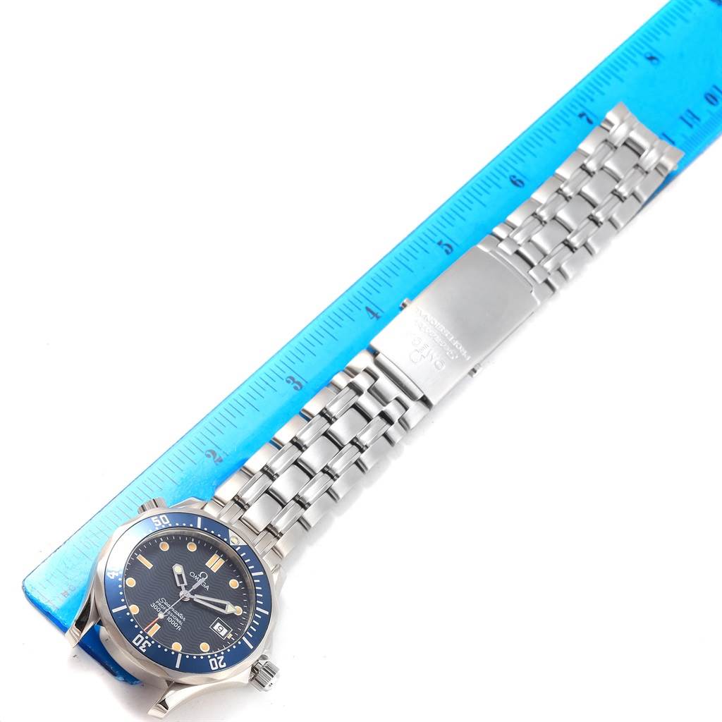 The image shows the Omega Seamaster 2561.80.00 Men's Stainless Steel Blue Dial 2561.80.00 Men's Stainless Steel Blue Dial watch, including its face, crown, bezel, bracelet, and clasp, laid flat next to a ruler.