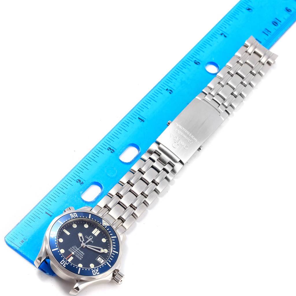 The Omega Seamaster 2551.80.00 Men
s Stainless Steel Blue Dial 2551.80.00 Men
s Stainless Steel Blue Dial watch is shown from a top-down angle, displaying the face and stainless steel band beside a ruler.