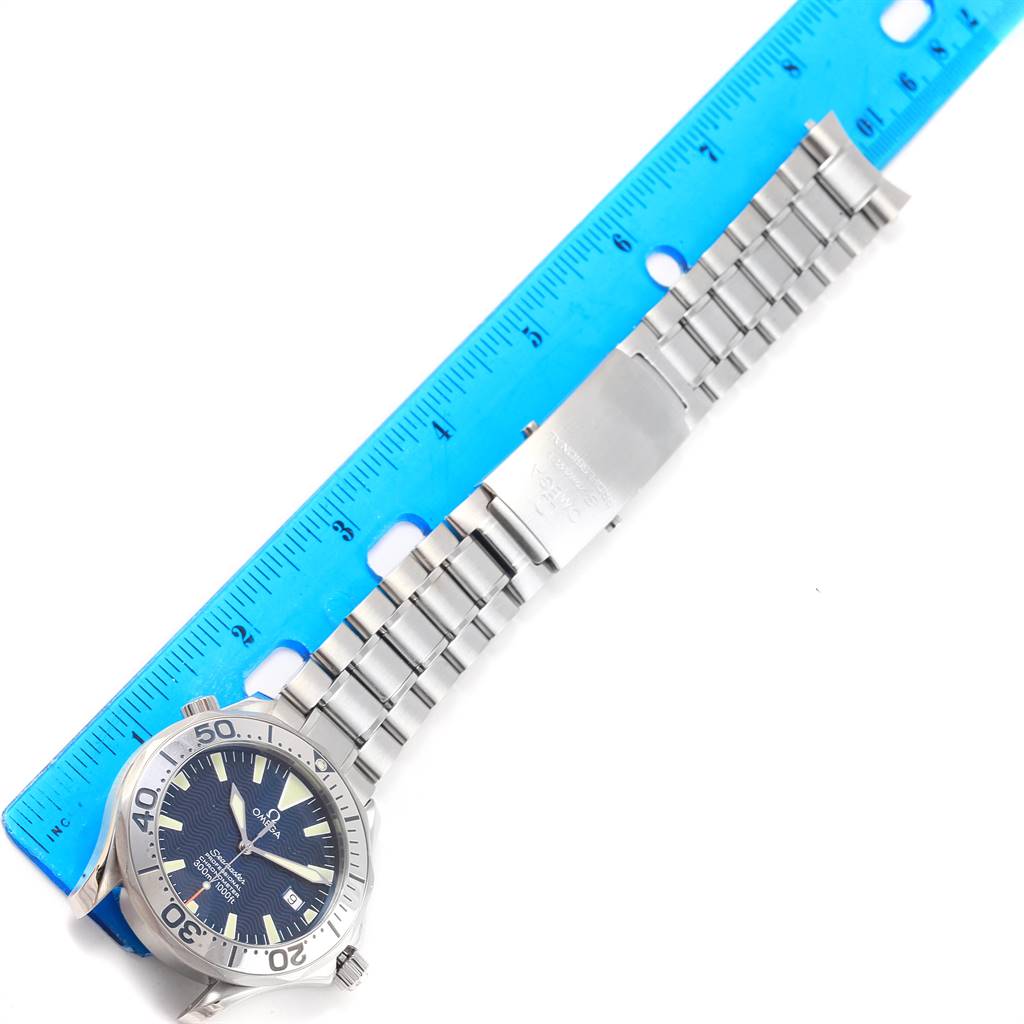 The image shows an Omega Seamaster 2255.80.00 Men
s Stainless Steel Blue Dial 2255.80.00 Men
s Stainless Steel Blue Dial watch and its metal bracelet, placed next to a blue ruler.