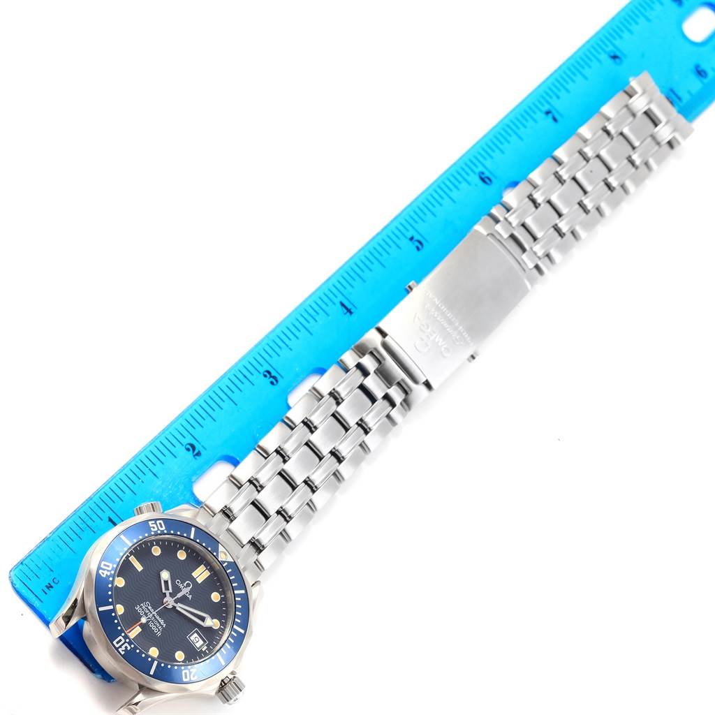 The image shows an Omega Seamaster 2561.80.00 Men
s Stainless Steel Blue Dial 2561.80.00 Men
s Stainless Steel Blue Dial watch laid flat alongside a blue ruler, displaying its face and metal bracelet.