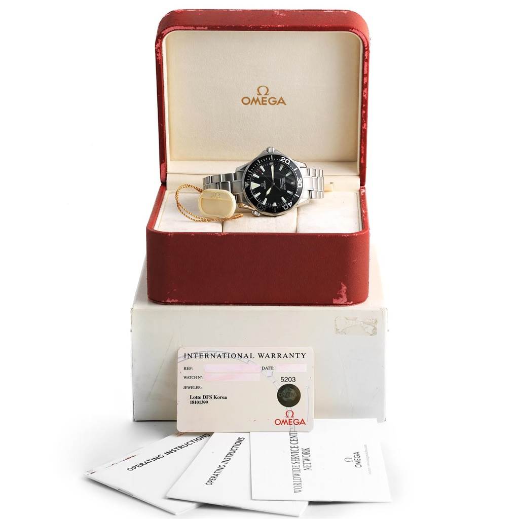 The image shows an Omega Seamaster 2264.50.00 Men
s Stainless Steel Black Dial 2264.50.00 Men
s Stainless Steel Black Dial watch in its open box with warranty papers and manuals placed in front.