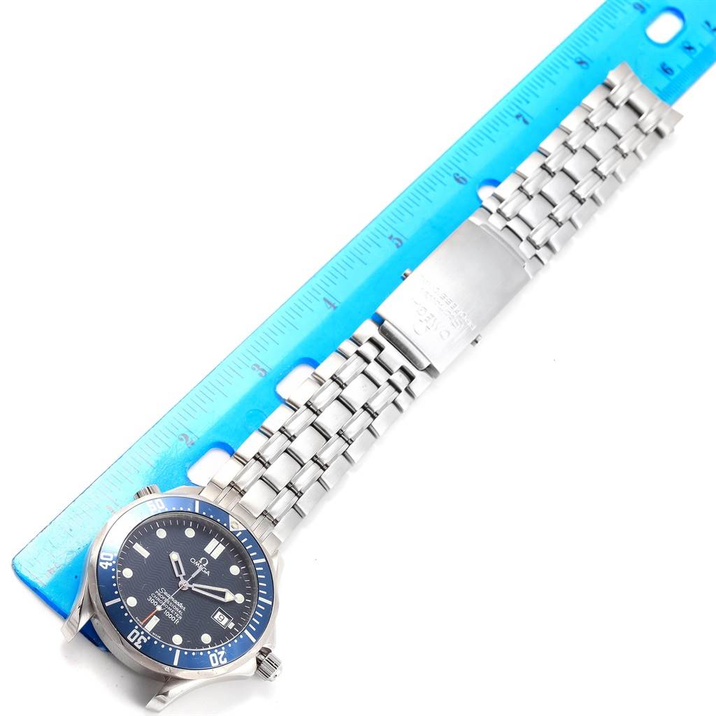 The Omega Seamaster 2531.80.00 Men
s Stainless Steel Blue Dial 2531.80.00 Men
s Stainless Steel Blue Dial watch is displayed at an angle, showing the face, bezel, and bracelet alongside a blue ruler for scale.