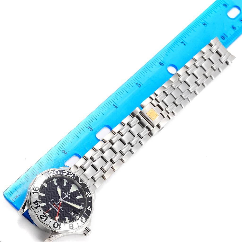 The image shows an Omega Seamaster 2534.50.00 Men
s Stainless Steel Black Dial 2534.50.00 Men
s Stainless Steel Black Dial watch face and partial stainless steel bracelet, measured against a blue ruler.