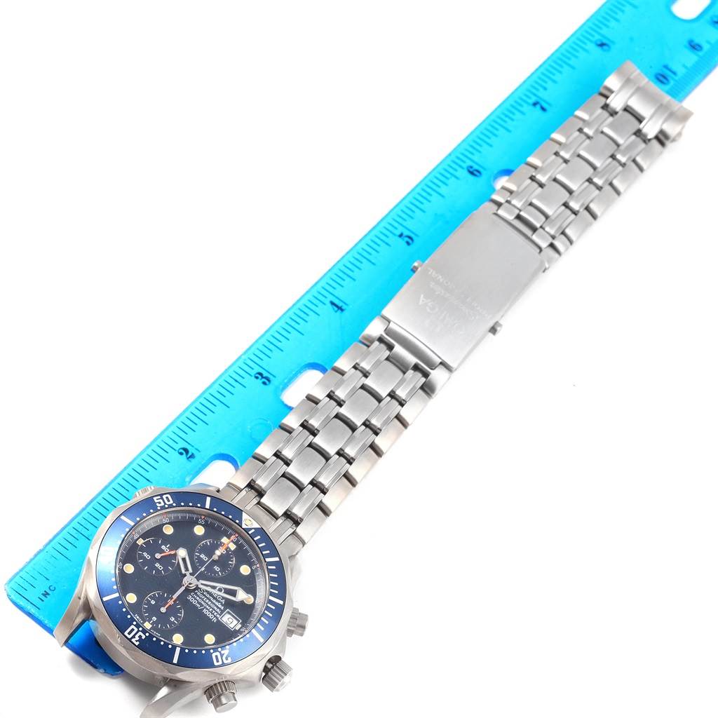 An Omega Seamaster 2298.80.00 Men
s Titanium Blue Dial 2298.80.00 Men
s Titanium Blue Dial watch is shown from above, displaying the face, bezel, and full metal bracelet alongside a blue measuring ruler.