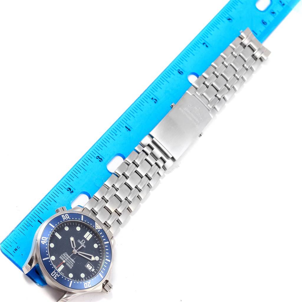 The image shows an Omega Seamaster 2531.80.00 Men
s Stainless Steel Blue Dial 2531.80.00 Men
s Stainless Steel Blue Dial watch laid flat with the face, bracelet, and clasp visible, next to a blue ruler for scale.