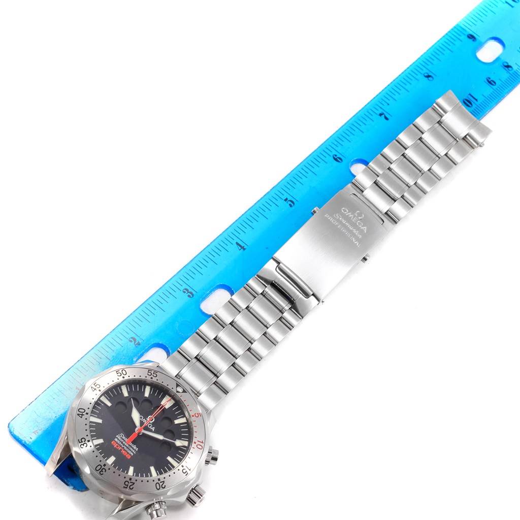 The image shows an Omega Seamaster 2595.50.00 Men
s Stainless Steel Black Dial 2595.50.00 Men
s Stainless Steel Black Dial watch laid next to a blue ruler, displaying the face, bezel, bracelet, and clasp.