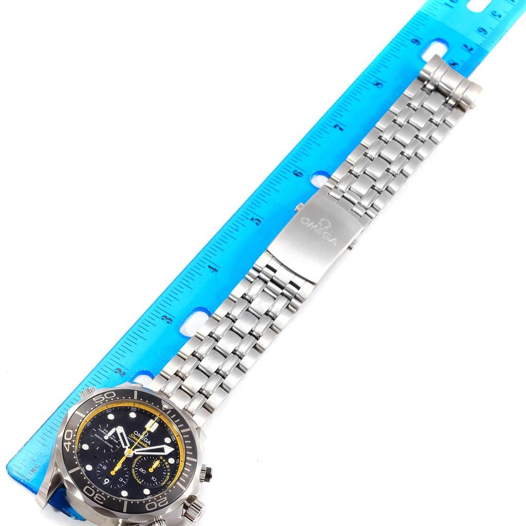 The Omega Seamaster 212.30.44.50.01.002 Men
s Stainless Steel Black Dial 212.30.44.50.01.002 Men
s Stainless Steel Black Dial watch is photographed from above, showing the face, bezel, band, and clasp next to a blue ruler.