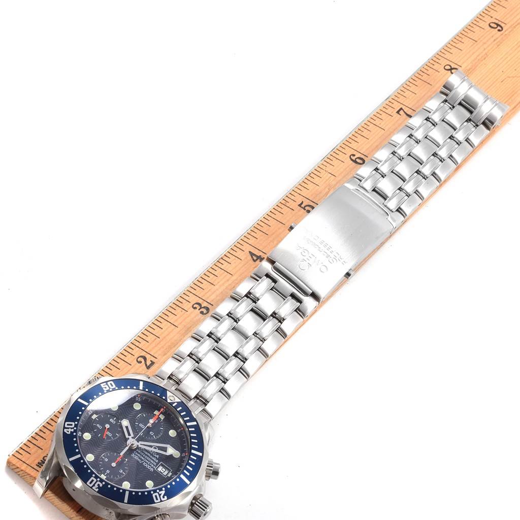 The image shows an Omega Seamaster 2599.80.00 Stainless Steel Blue Dial 2599.80.00 Stainless Steel Blue Dial watch laid flat against a ruler, displaying the dial, bezel, and metal bracelet.