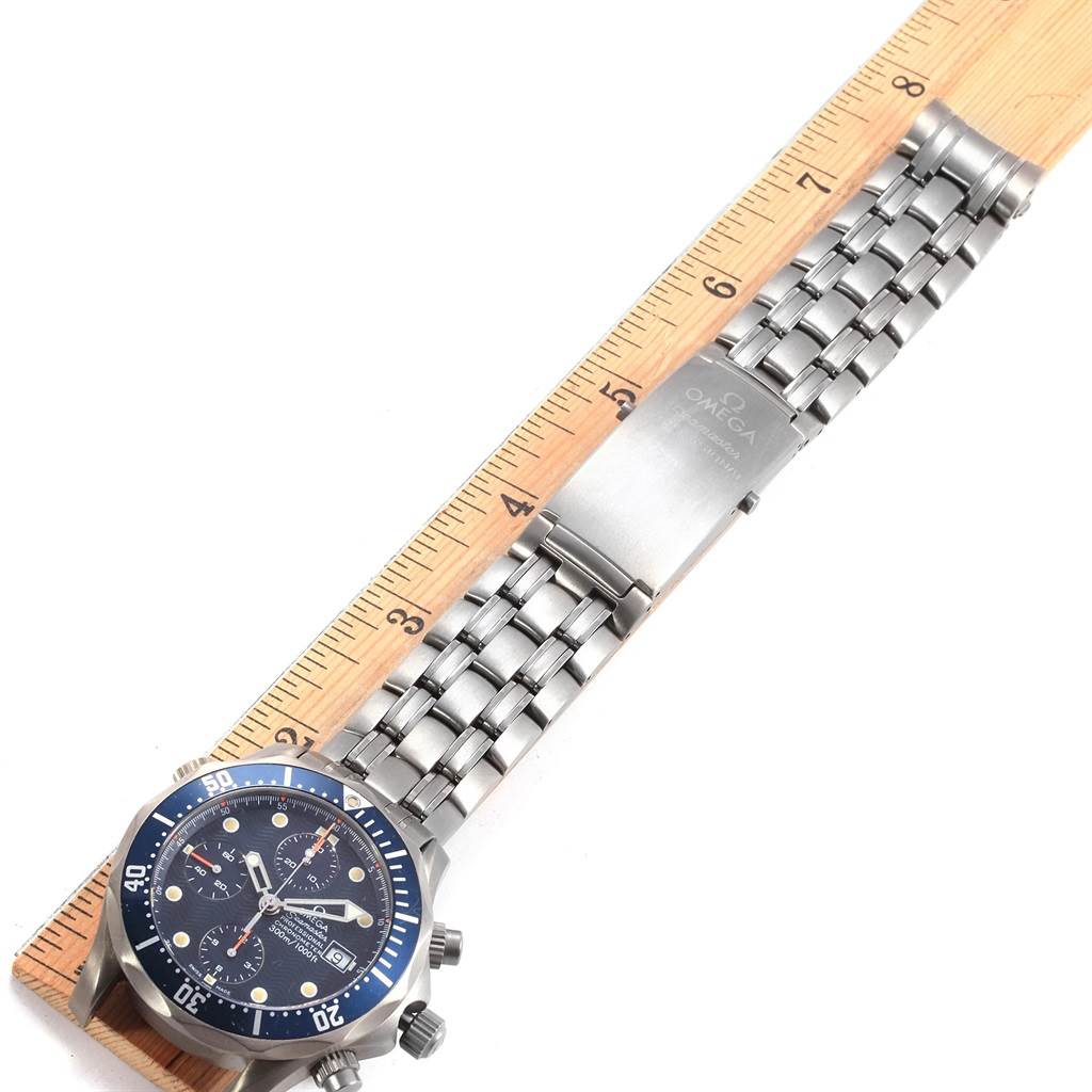 The Omega Seamaster 2298.80.00 Men
s Titanium Blue Dial 2298.80.00 Men
s Titanium Blue Dial watch is shown laying flat with the face, bezel, and stainless steel bracelet visible, aligned next to a ruler.