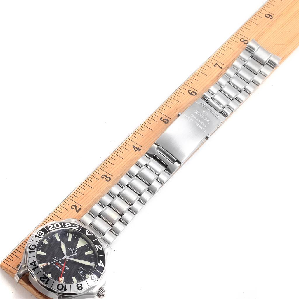 The Omega Seamaster 2536.50.00 Men's Stainless Steel Black Dial 2536.50.00 Men's Stainless Steel Black Dial watch is displayed flat showing the face, bezel, and entire metal bracelet alongside a ruler for scale.