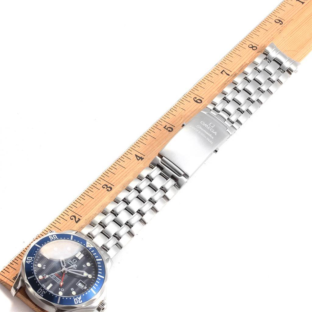 The image shows an Omega Seamaster 2535.80.00 Men
s Stainless Steel Blue Dial 2535.80.00 Men
s Stainless Steel Blue Dial watch laid flat, featuring its face, bezel, and metal bracelet next to a ruler for scale.