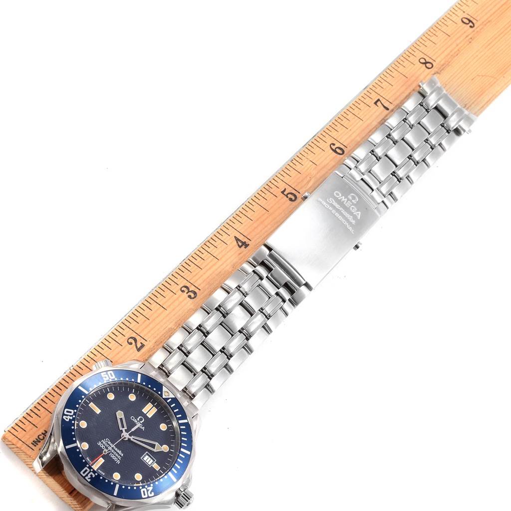 The image shows an Omega Seamaster 2541.80.00 Men
s Stainless Steel Blue Dial 2541.80.00 Men
s Stainless Steel Blue Dial watch laying flat, displaying the face, bezel, and full metal bracelet next to a wooden ruler.
