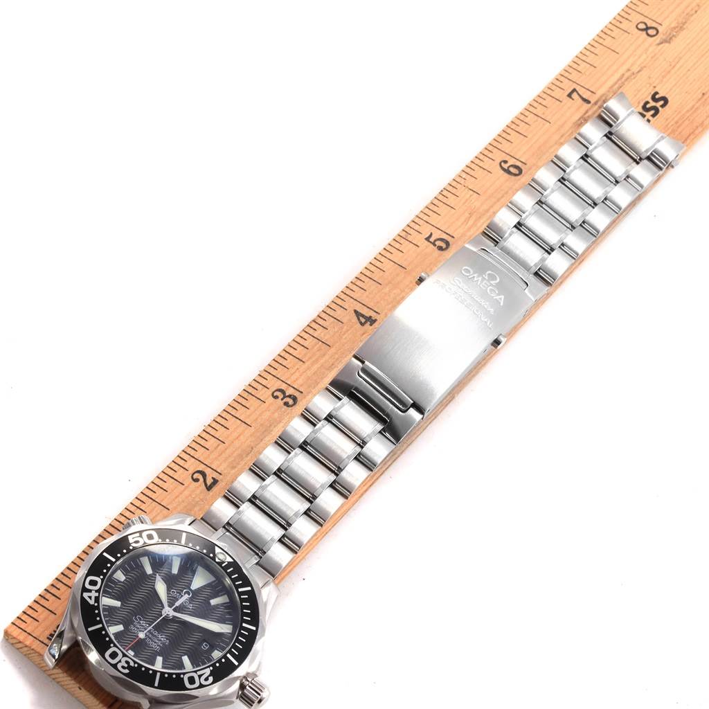 The Omega Seamaster 2262.50.00 Men
s Stainless Steel Black Dial 2262.50.00 Men
s Stainless Steel Black Dial watch is shown from a top-down angle, highlighting its face, bezel, stainless steel bracelet, and branded clasp next to a ruler.