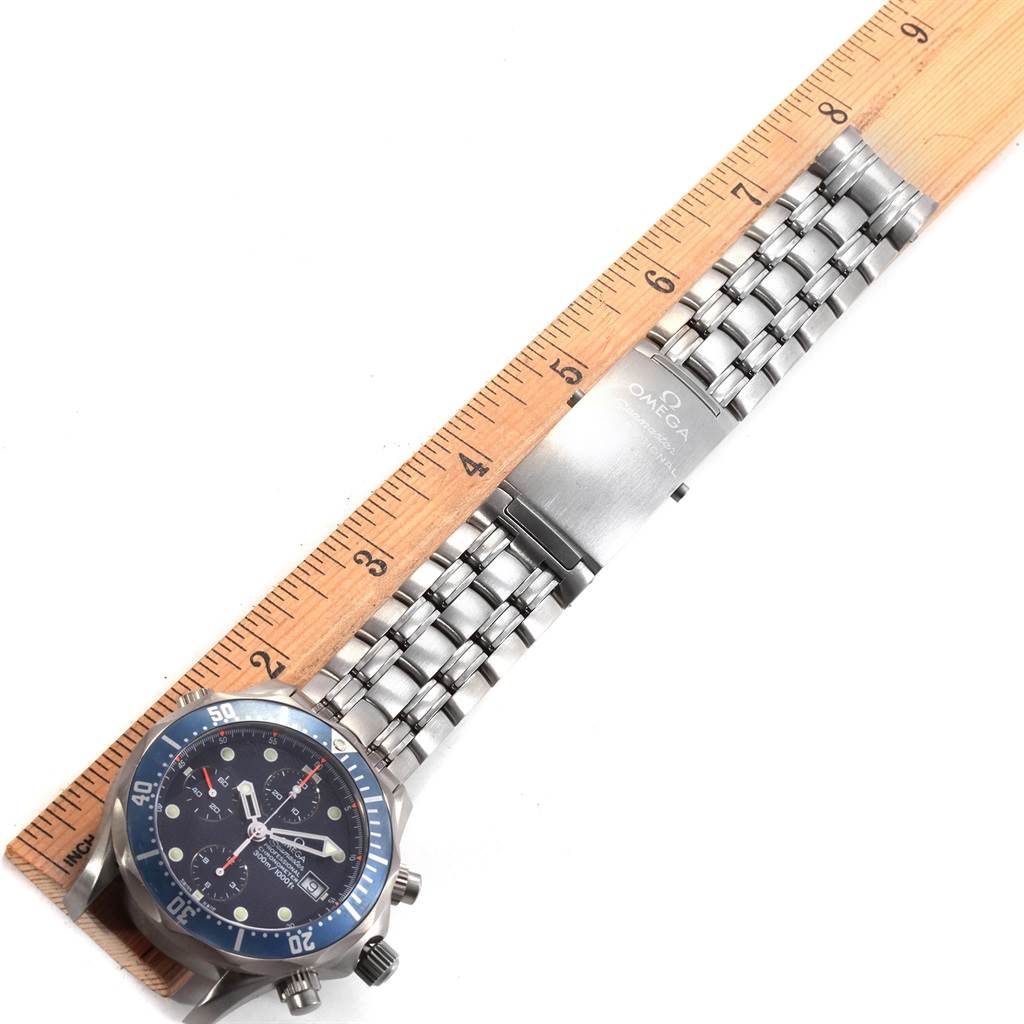 The image shows an Omega Seamaster 2298.80.00 Men
s Titanium Blue Dial 2298.80.00 Men
s Titanium Blue Dial watch lying flat with its bracelet aligned alongside a wooden ruler.