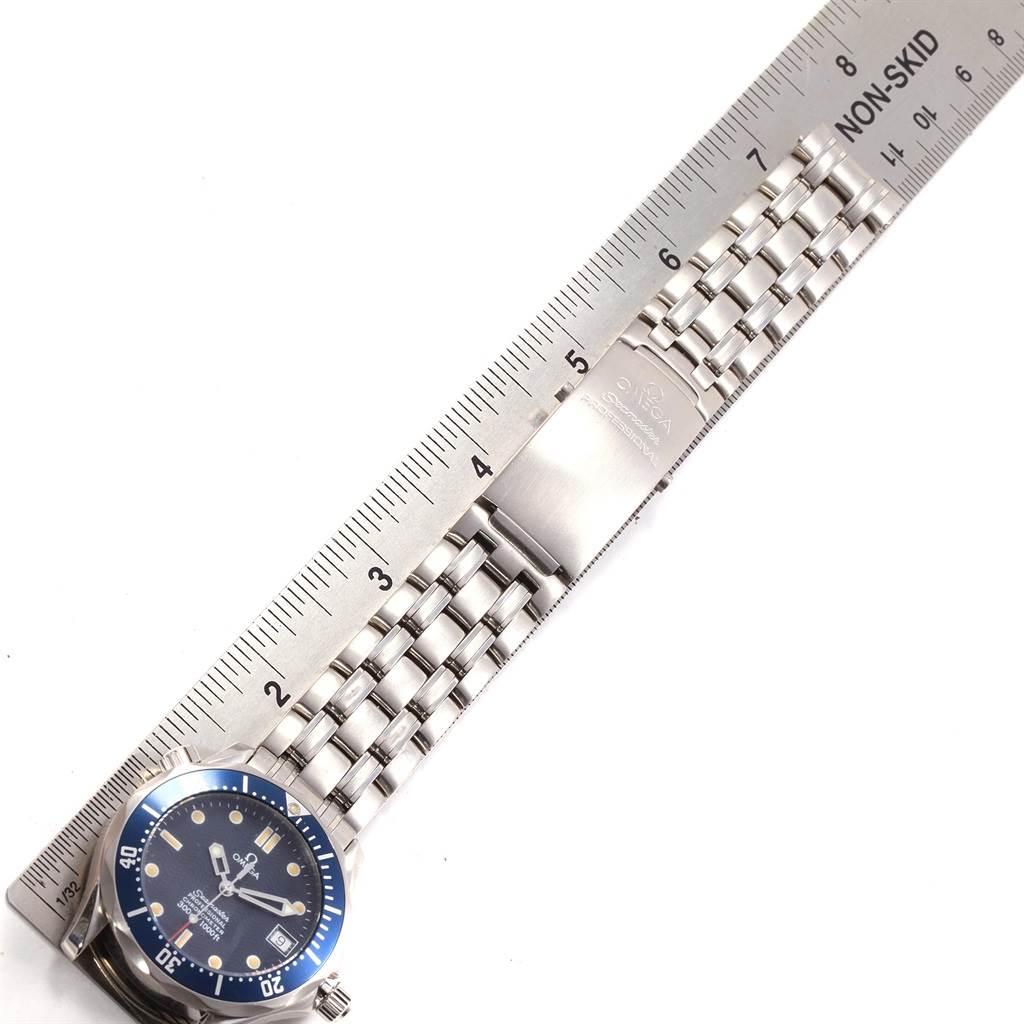 The image shows an Omega Seamaster 2551.80.00 Men's Stainless Steel Blue Dial 2551.80.00 Men's Stainless Steel Blue Dial watch at an angle, highlighting its band and clasp against a ruler for measurement.