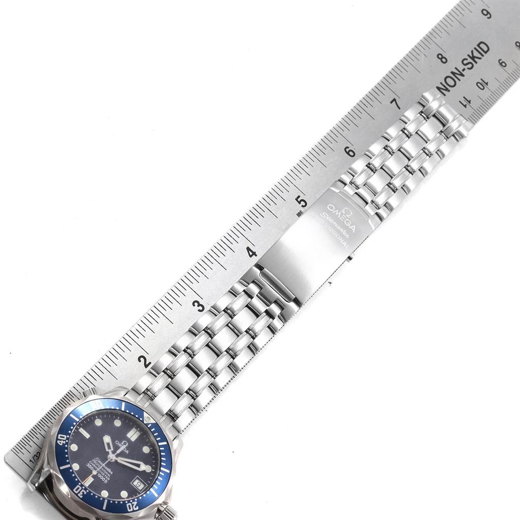 The image shows an Omega Seamaster 2551.80.00 Men
s Stainless Steel Blue Dial 2551.80.00 Men
s Stainless Steel Blue Dial watch laid next to a ruler, highlighting its face and metal bracelet.