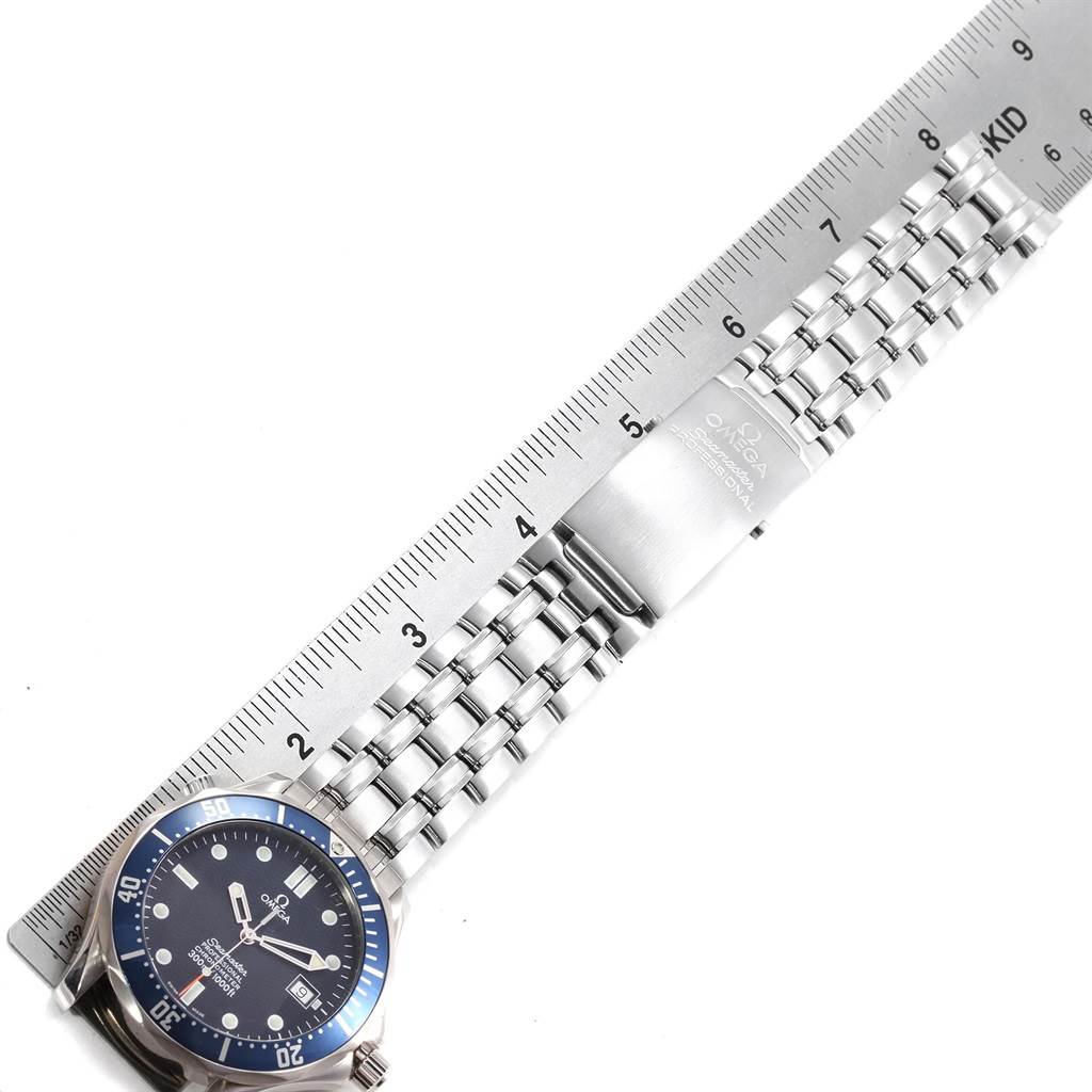 The image shows an Omega Seamaster 2531.80.00 Men
s Stainless Steel Blue Dial 2531.80.00 Men
s Stainless Steel Blue Dial watch from an overhead angle, featuring its face and metal bracelet with a clasp placed alongside a ruler.