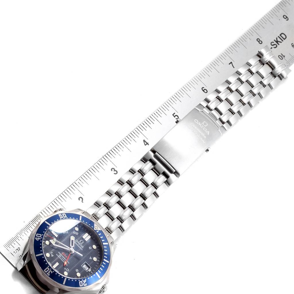 The image shows an Omega Seamaster 2535.80.00 Men
s Stainless Steel Blue Dial 2535.80.00 Men
s Stainless Steel Blue Dial watch laid flat alongside a ruler, displaying the watch face and the metal band with its clasp.