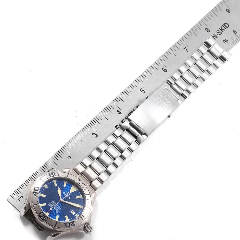 The image shows the Omega Seamaster 2255.80.00 Men
s Stainless Steel Blue Dial 2255.80.00 Men
s Stainless Steel Blue Dial watch from a top view, featuring the face, bezel, and a portion of the metal bracelet alongside a ruler.