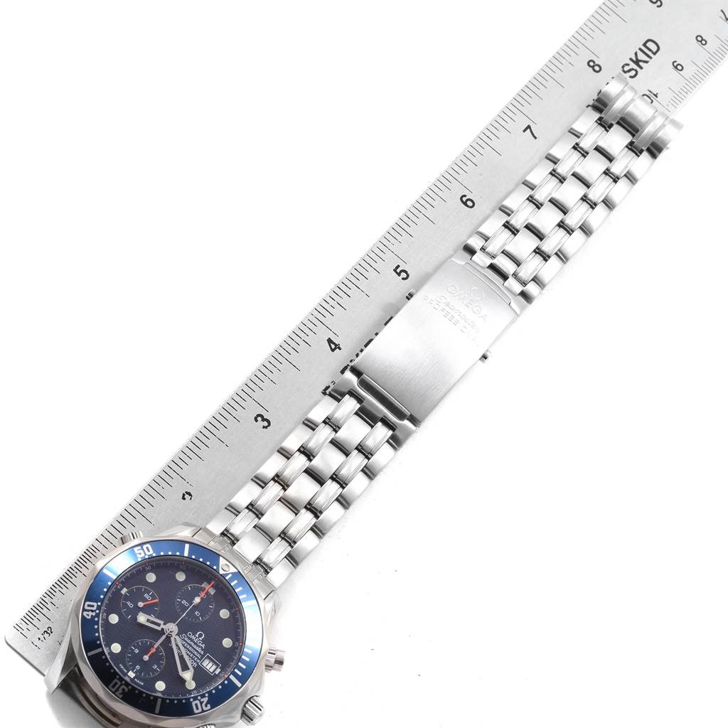 The image shows an Omega Seamaster 2599.80.00 Men
s Stainless Steel Blue Dial 2599.80.00 Men
s Stainless Steel Blue Dial watch laid flat on a surface with a ruler along its length, displaying its face and stainless steel bracelet.