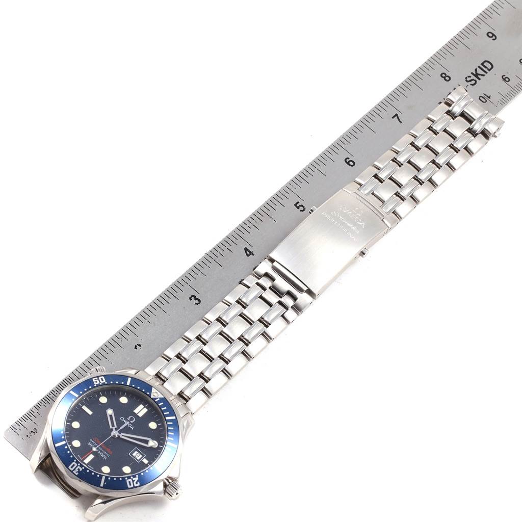 The image shows a side angle of an Omega Seamaster 2221.80.00 Men
s Stainless Steel Blue Dial 2221.80.00 Men
s Stainless Steel Blue Dial watch, including its bezel, dial, and bracelet next to a ruler for measurement.