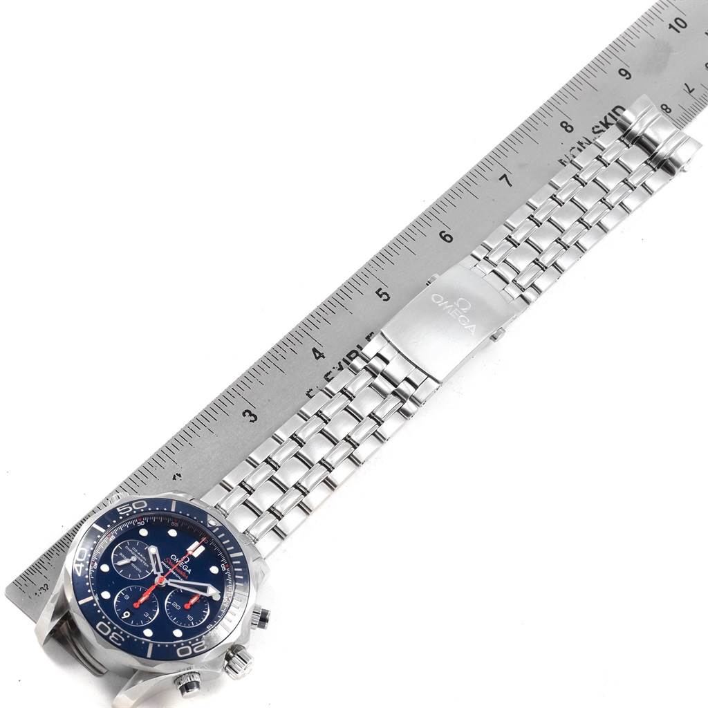 The image shows an Omega Seamaster 212.30.44.50.03.001 Men
s Stainless Steel Blue Dial 212.30.44.50.03.001 Men
s Stainless Steel Blue Dial watch laid flat next to a ruler, highlighting its metal bracelet and clasp.