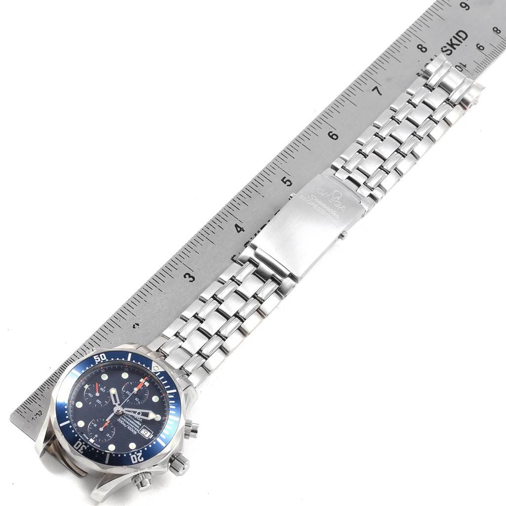 This image shows the Omega Seamaster 2599.80.00 Men
s Stainless Steel Blue Dial 2599.80.00 Men
s Stainless Steel Blue Dial watch lying flat with its silver metal bracelet extended alongside a ruler.