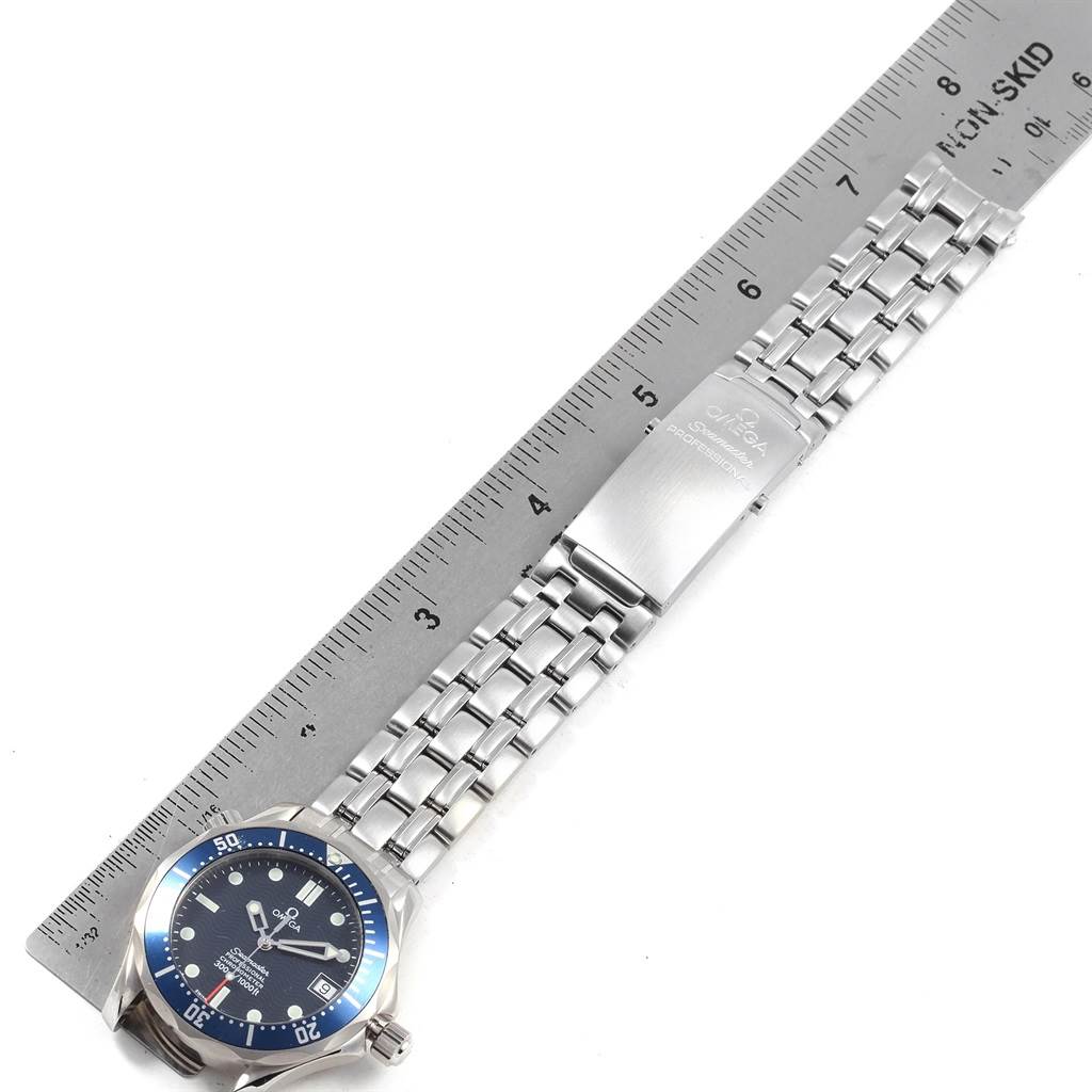 The image displays an Omega Seamaster 2551.80.00 Men
s Stainless Steel Blue Dial 2551.80.00 Men
s Stainless Steel Blue Dial watch from a top view, showing the dial, bezel, bracelet, and clasp along with a measurement ruler.