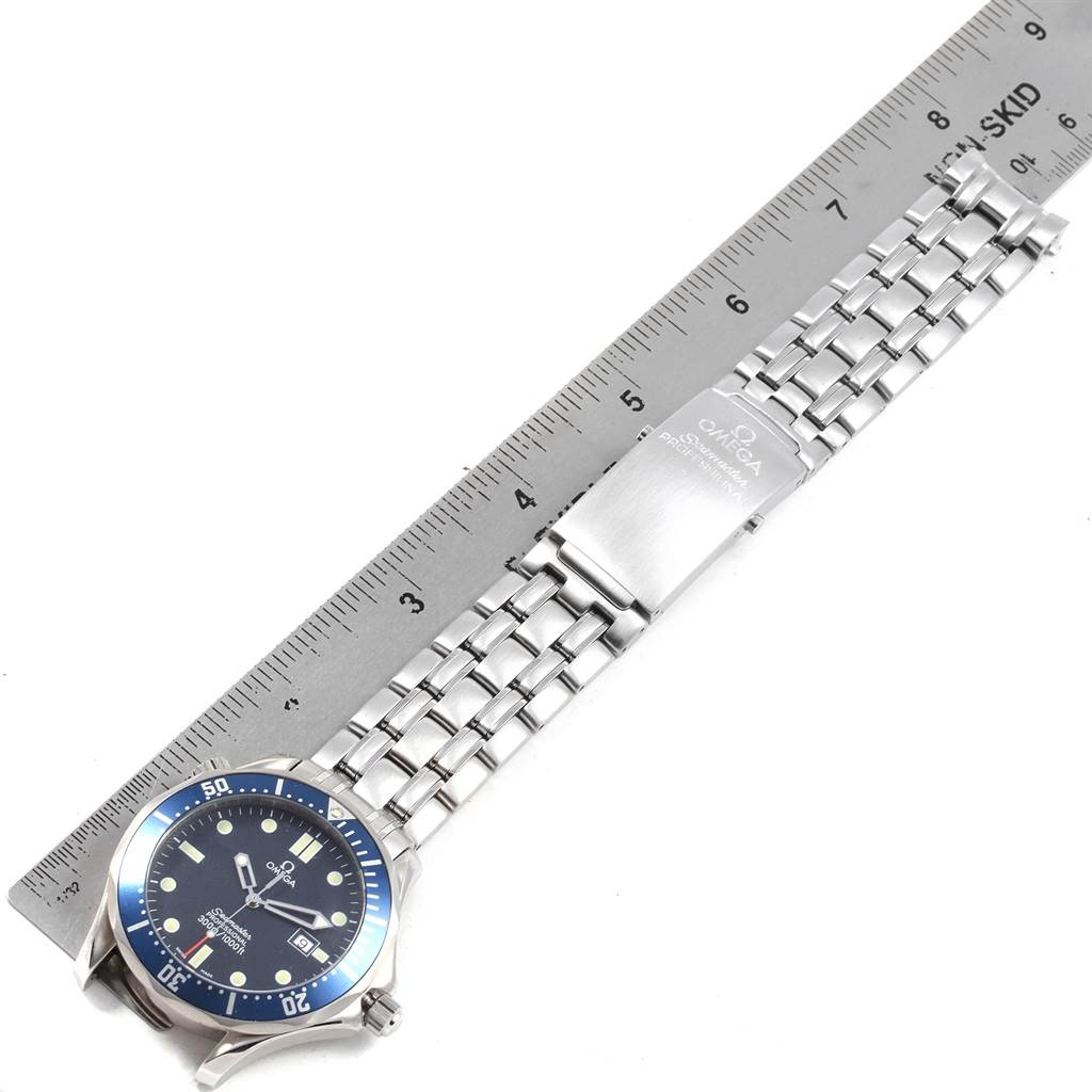 The image shows an Omega Seamaster 2541.80.00 Men
s Stainless Steel Blue Dial 2541.80.00 Men
s Stainless Steel Blue Dial watch laid flat with a metal ruler measuring its stainless steel bracelet.