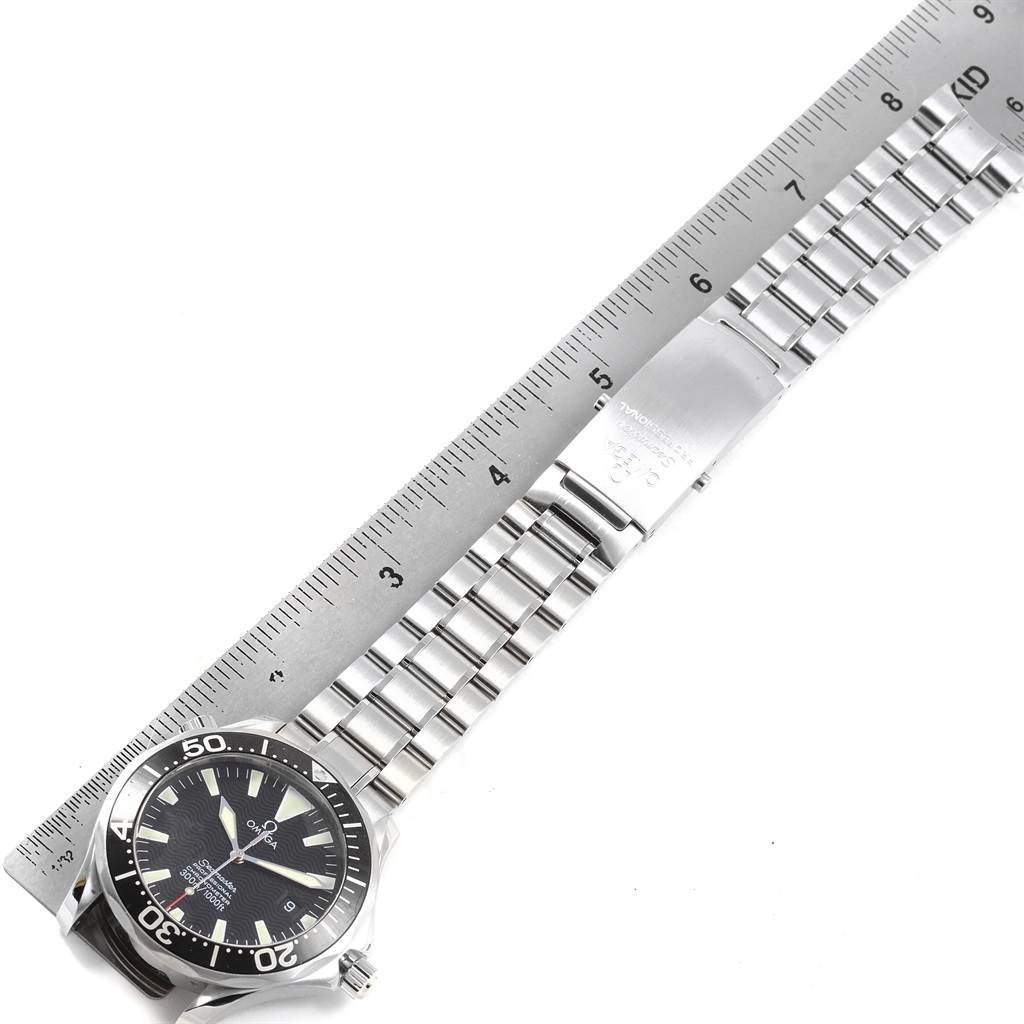 The image shows an Omega Seamaster 2254.50.00 Men
s Stainless Steel Black Dial 2254.50.00 Men
s Stainless Steel Black Dial watch from a top-down angle, featuring the watch face and stainless steel band next to a ruler.