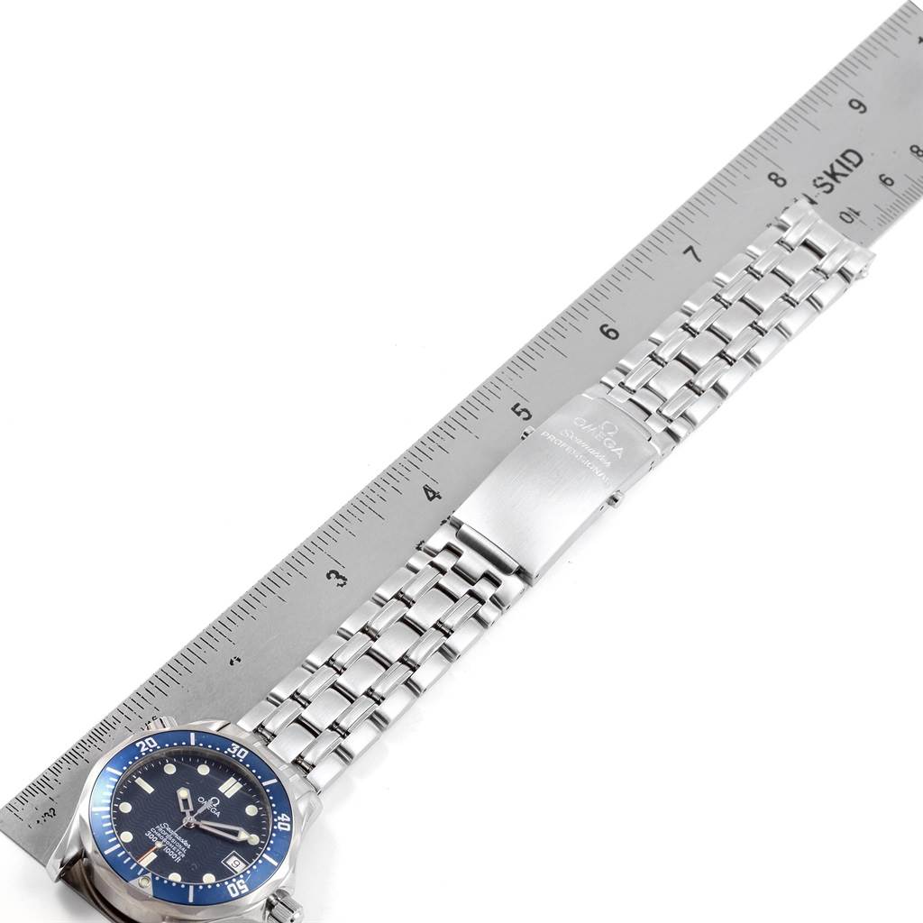 The image shows an Omega Seamaster 2551.80.00 Men
s Stainless Steel Blue Dial 2551.80.00 Men
s Stainless Steel Blue Dial watch laid flat next to a ruler, displaying the face and band.
