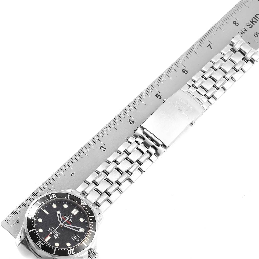 The image shows the Omega Seamaster 212.30.41.20.01.002 Men
s Stainless Steel Black Dial 212.30.41.20.01.002 Men
s Stainless Steel Black Dial watch face partially along with its metal bracelet placed next to a ruler.