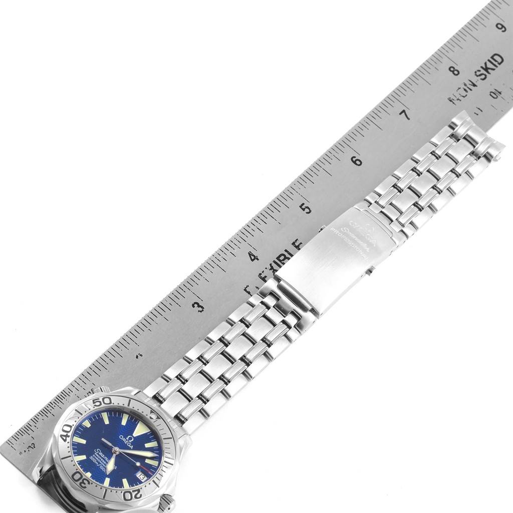 The image shows an Omega Seamaster 2053.80.00 Men's Stainless Steel Blue Dial 2053.80.00 Men's Stainless Steel Blue Dial watch with its band laid out beside a ruler, highlighting the bracelet and clasp.