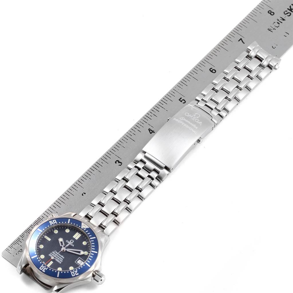 The Omega Seamaster 2551.80.00 Men
s Stainless Steel Blue Dial 2551.80.00 Men
s Stainless Steel Blue Dial watch is shown from a top-down view, displaying the face, bezel, and metal bracelet alongside a ruler.