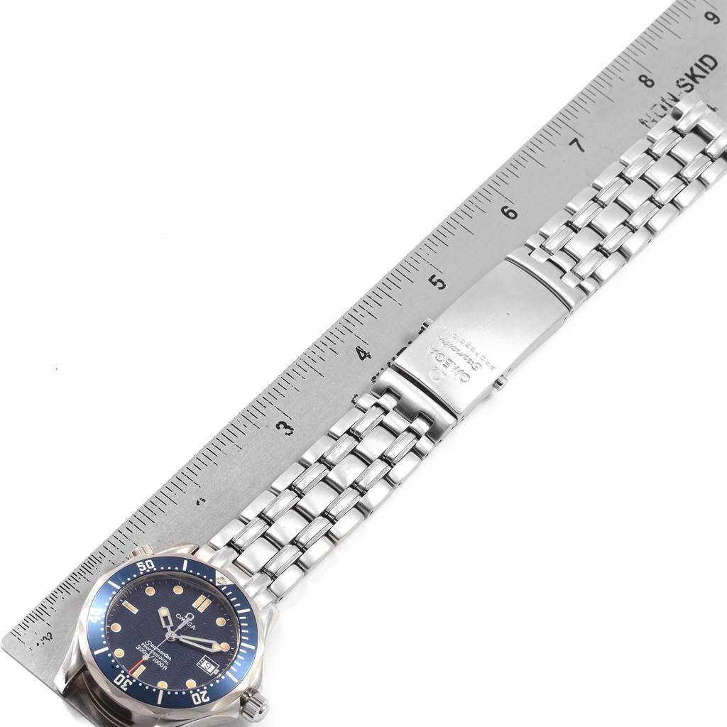 The image shows a side view of an Omega Seamaster 2561.80.00 Men
s Stainless Steel Blue Dial 2561.80.00 Men
s Stainless Steel Blue Dial watch laid flat, with its bracelet and clasp visible alongside a ruler.