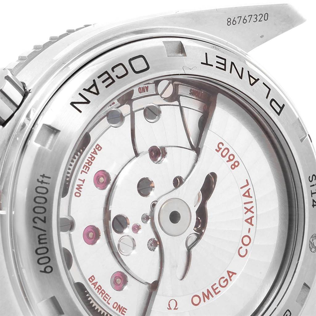 The image shows a close-up of the back of an Omega Seamaster 232.30.44.22.03.001 Men
s Stainless Steel Blue Dial 232.30.44.22.03.001 Men
s Stainless Steel Blue Dial watch, displaying its internal mechanism and "co-axial" components.