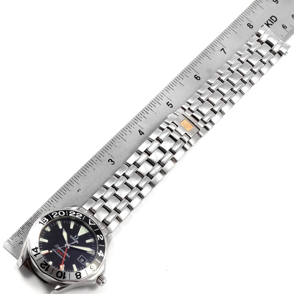 The image shows the Omega Seamaster 2534.50.00 Men
s Stainless Steel Black Dial 2534.50.00 Men
s Stainless Steel Black Dial watch from a top-down angle, highlighting the bezel, dial, and metal bracelet alongside a ruler.