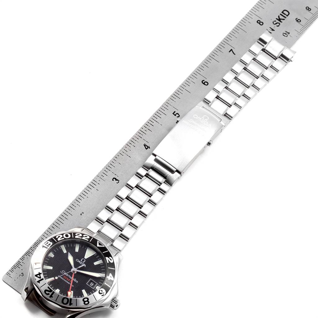 The image shows an Omega Seamaster 2234.50.00 Men
s Stainless Steel Black Dial 2234.50.00 Men
s Stainless Steel Black Dial watch from a top-down angle, highlighting the face, bezel, and stainless steel bracelet measured against a ruler.