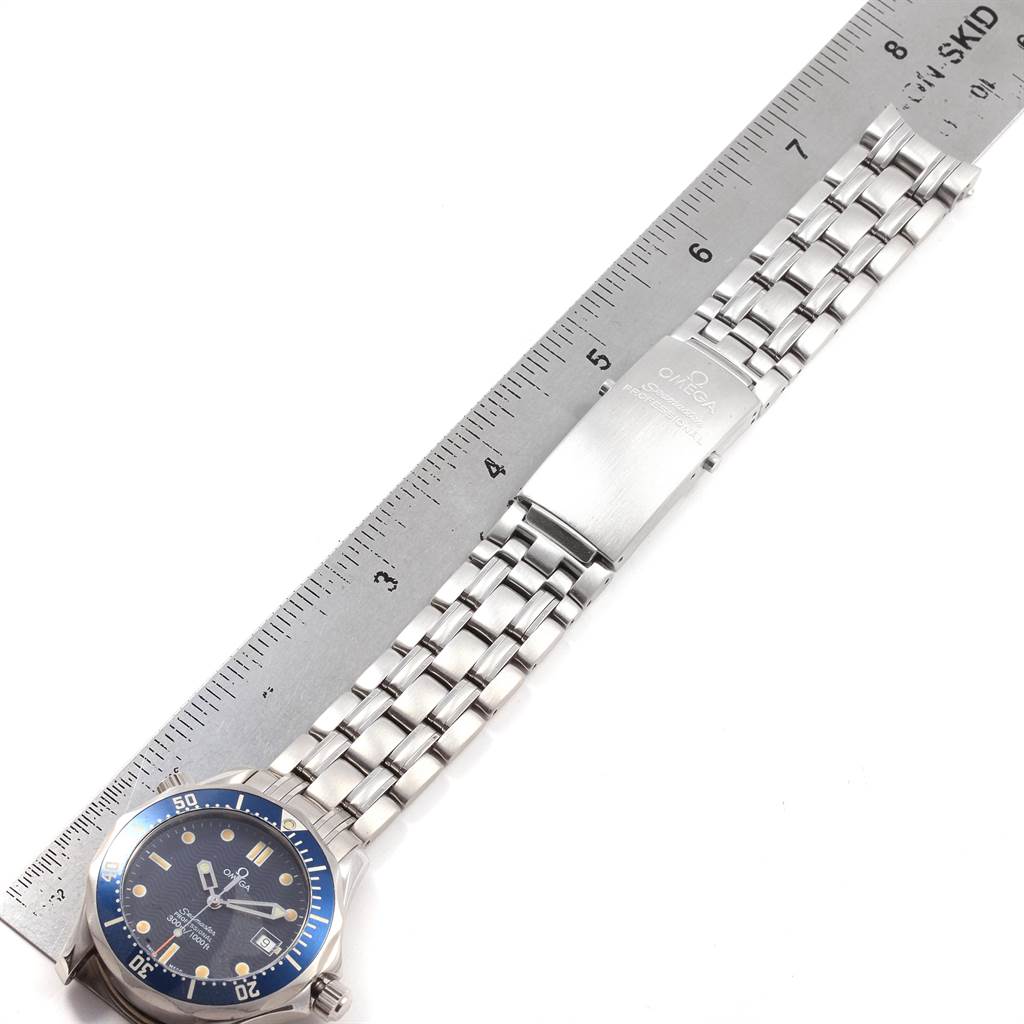 The image shows an Omega Seamaster 2561.80.00 Men
s Stainless Steel Blue Dial 2561.80.00 Men
s Stainless Steel Blue Dial watch with a metal bracelet, laid next to a ruler for scale.