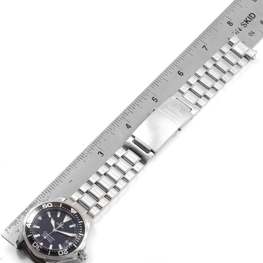 The image shows a side view of an Omega Seamaster 2262.50.00 Men
s Stainless Steel Black Dial 2262.50.00 Men
s Stainless Steel Black Dial watch with its dial, bezel, and metal bracelet placed alongside a ruler for scale.