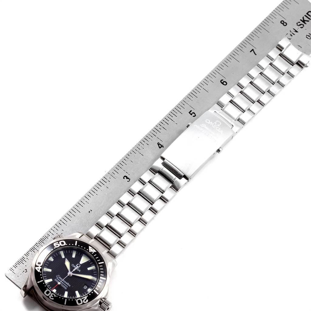 This image shows an Omega Seamaster 2262.50.00 Men
s Stainless Steel Black Dial 2262.50.00 Men
s Stainless Steel Black Dial watch laid flat with a metal ruler measuring its stainless steel bracelet.