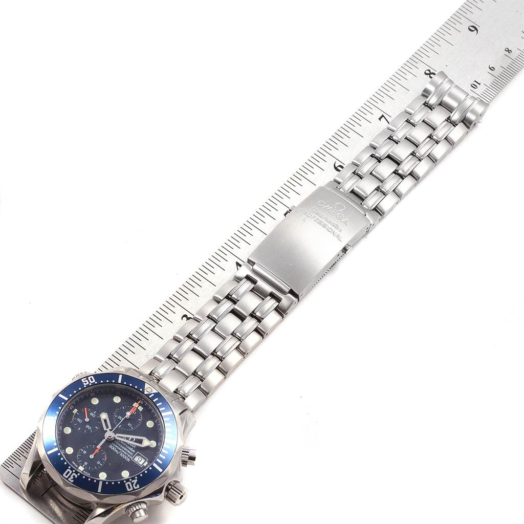 The image shows an Omega Seamaster 2599.80.00 Men
s Stainless Steel Blue Dial 2599.80.00 Men
s Stainless Steel Blue Dial watch lying flat with its band, clasp, and bezel with a measuring scale beneath.