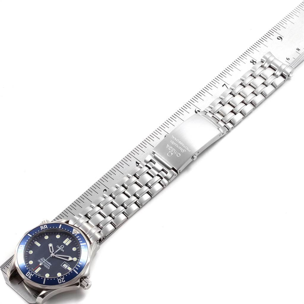 The image shows an Omega Seamaster 2541.80.00 Men
s Stainless Steel Blue Dial 2541.80.00 Men
s Stainless Steel Blue Dial watch from an overhead angle, featuring the face, bezel, and metal bracelet against a ruler.