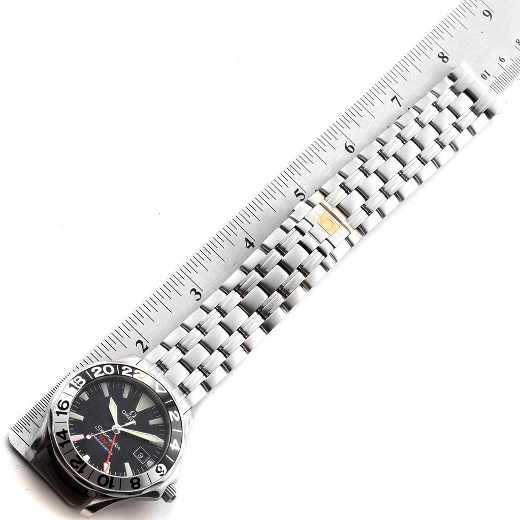 The Omega Seamaster 2534.50.00 Men
s Stainless Steel Black Dial 2534.50.00 Men
s Stainless Steel Black Dial watch is shown from a top-down angle, displaying the face, bezel, and bracelet alongside a ruler for scale.