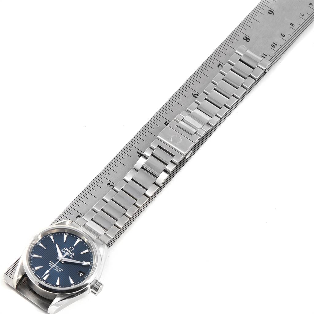 The Omega Seamaster 231.10.39.21.03.002 Men's Stainless Steel Blue Dial 231.10.39.21.03.002 Men's Stainless Steel Blue Dial watch is shown from a top-down angle, displaying its face, metal bracelet, and clasp alongside a ruler for scale.