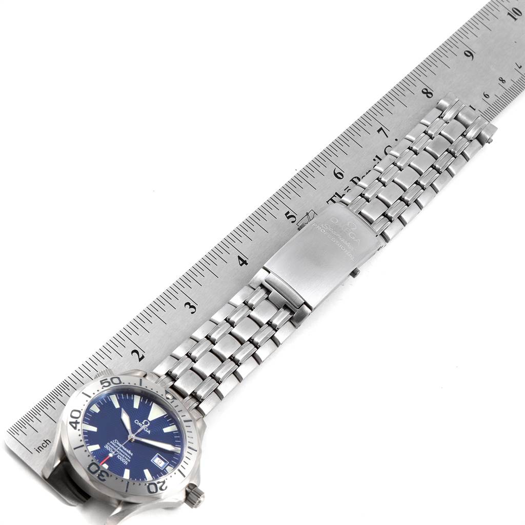 This image shows an Omega Seamaster 2231.80.00 Men
s Titanium Blue Dial 2231.80.00 Men
s Titanium Blue Dial watch laid flat next to a ruler, highlighting its bracelet and clasp.