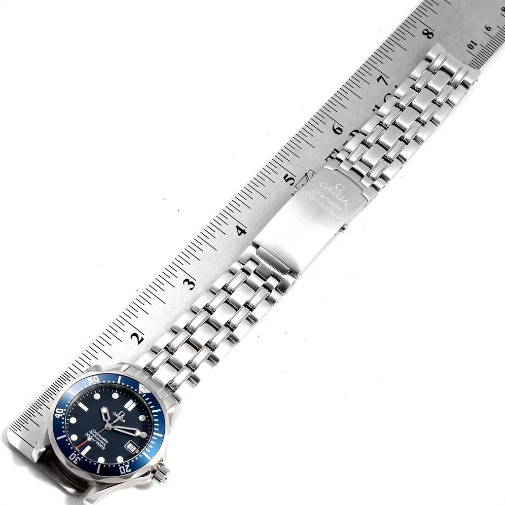 This image displays the Omega Seamaster 2561.80.00 Men
s Stainless Steel Blue Dial 2561.80.00 Men
s Stainless Steel Blue Dial watch from a top-down angle, showing the watch face, bezel, bracelet, and clasp alongside a ruler.