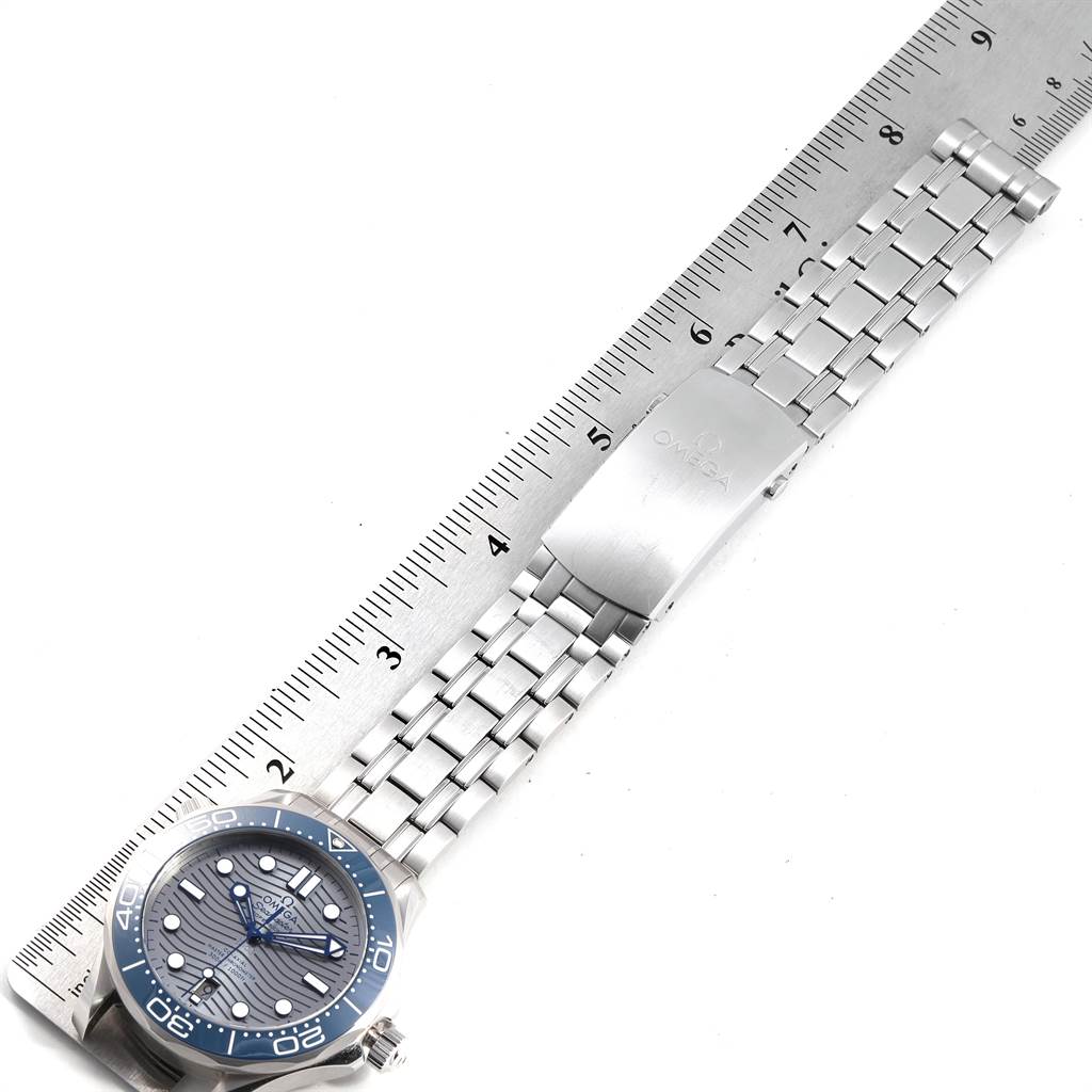 The image shows an Omega Seamaster 210.30.42.20.06.001 Men
s Stainless Steel Grey Dial 210.30.42.20.06.001 Men
s Stainless Steel Grey Dial watch from a top view, featuring its dial and metal bracelet measured against a ruler.