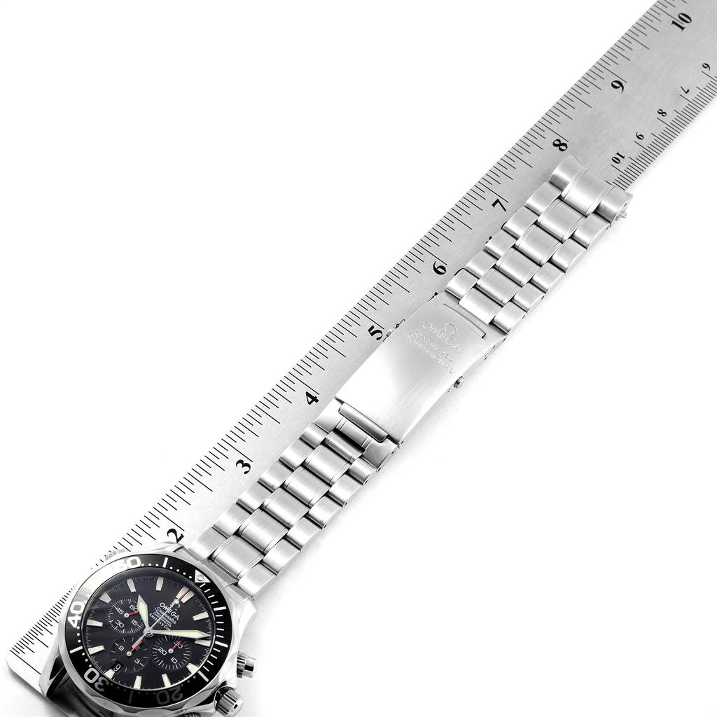 The image shows an Omega Seamaster 2594.50.00 Men
s Stainless Steel Black Dial 2594.50.00 Men
s Stainless Steel Black Dial watch laid flat next to a ruler, showcasing its face, bezel, and metal bracelet with clasp.